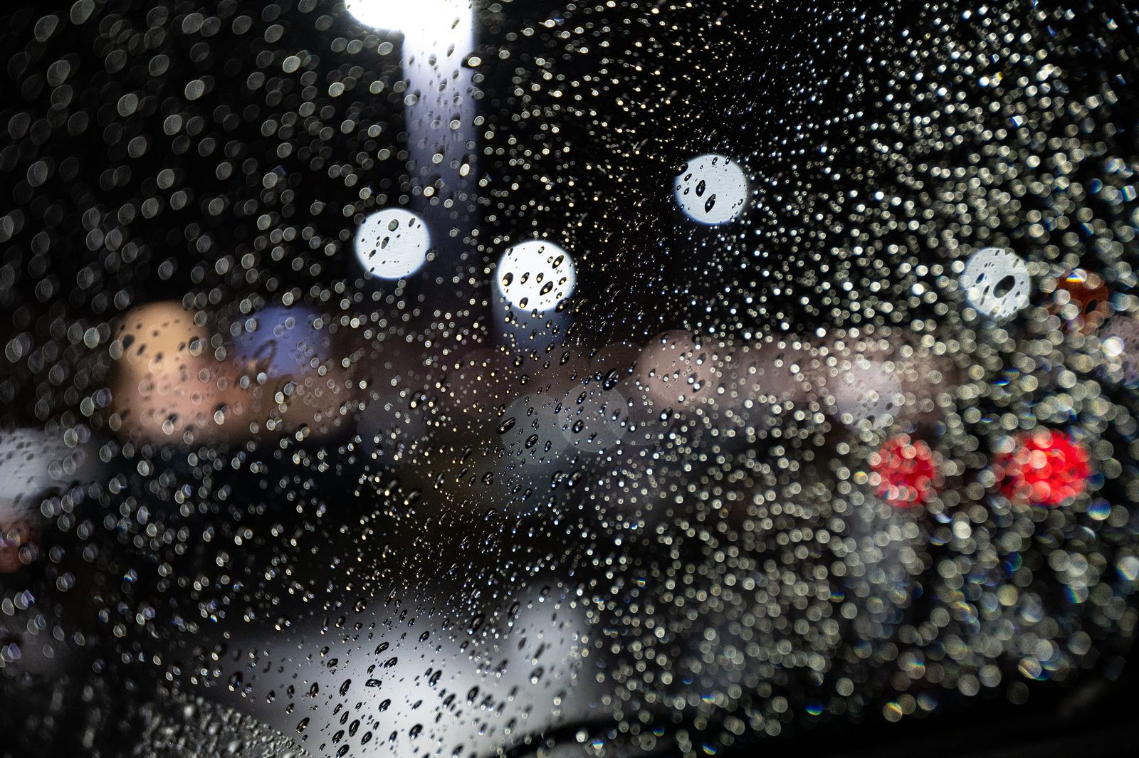 Water droplets on a windshield at night