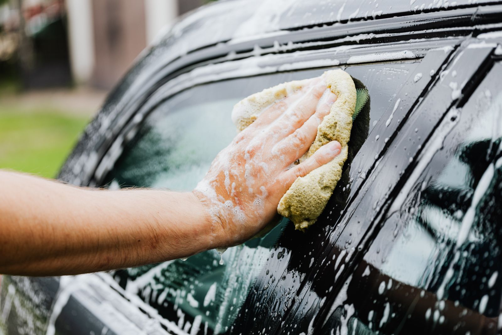Finisher scrubbing a car window by hand