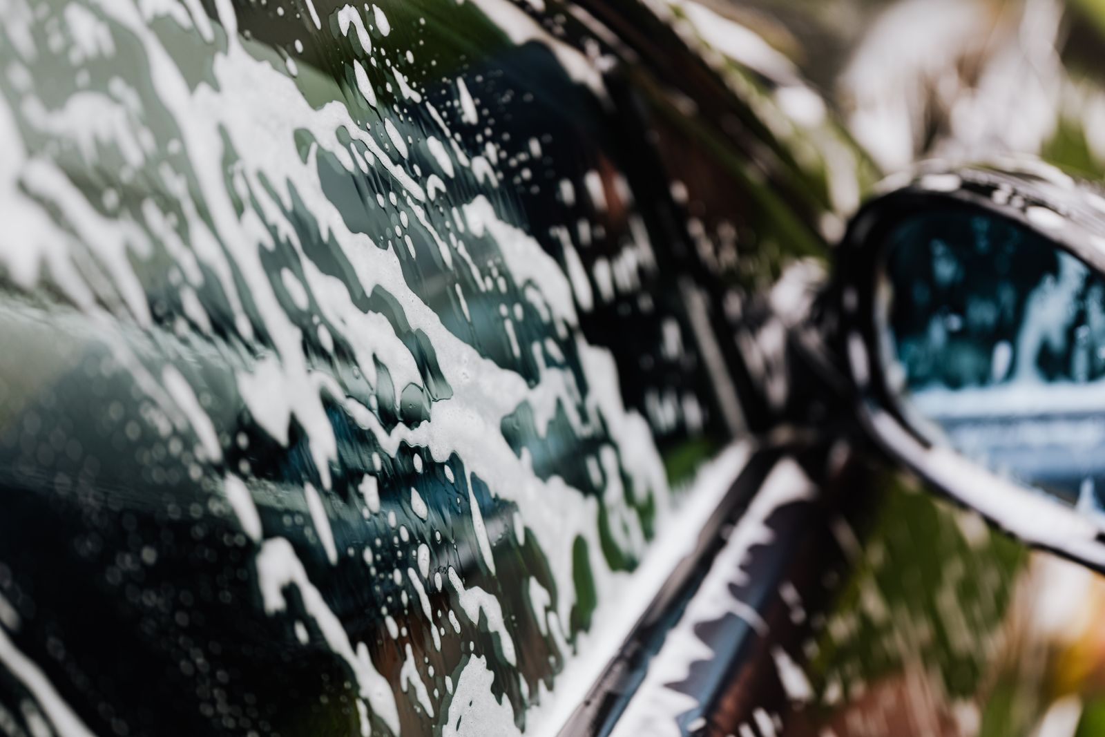 Snow foam covering the lower panels of a car